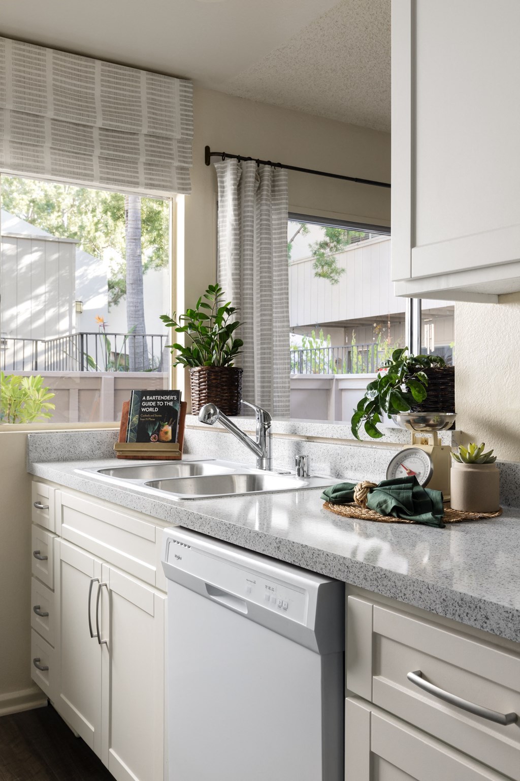 Kitchen with whirlpool appliances and white shaker cabinetry at Cerritos Apartments