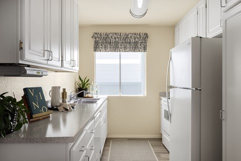 Kitchen with a large window at Crystal Springs apartments in Fountain Valley.