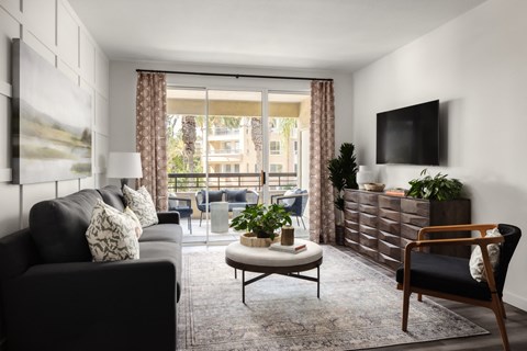 Model living room and balcony at City Lights at Town Center Apartments in Aliso Viejo