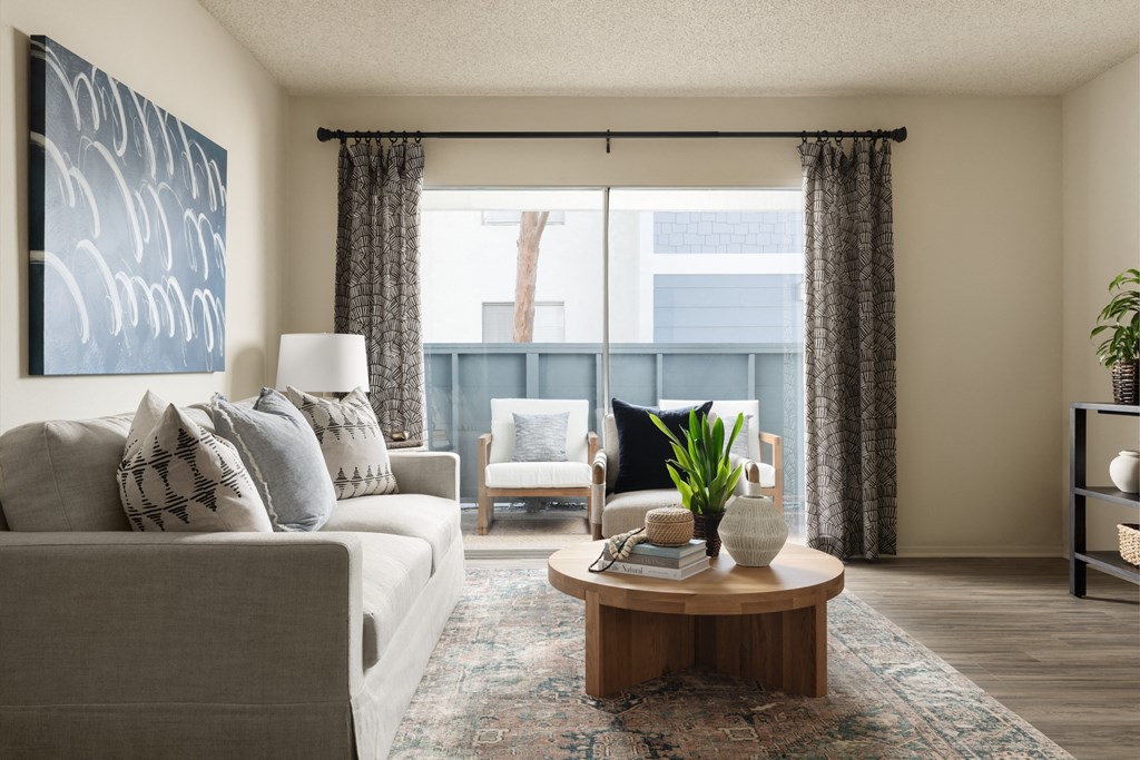 Living room with a balcony at Crystal Springs apartments in Fountain Valley.
