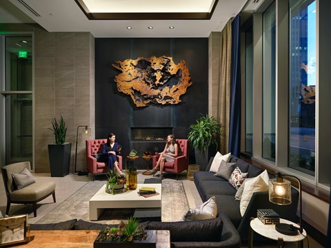 A woman is sitting on a red chair in a modern living room.