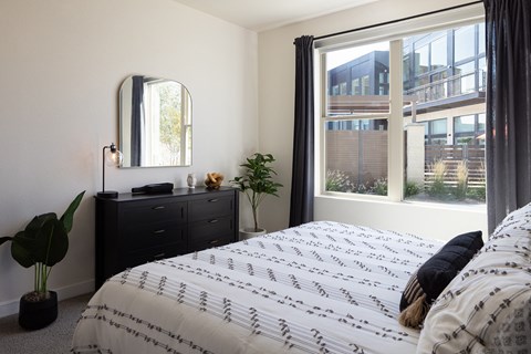 A bedroom with a large bed and a large window.