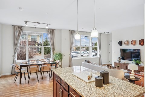 A kitchen with a table and chairs in front of a window.
