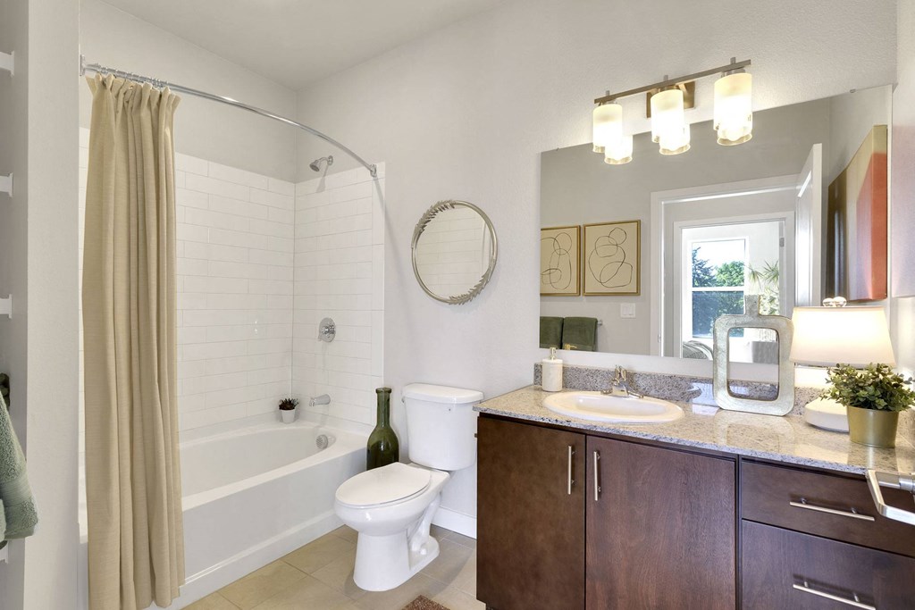 Bathroom with oval tub and granite counters at The York on City Park in Denver