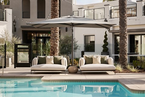 Poolside view with comfortable seating at City Lights at Town Center Apartments in Aliso Viejo