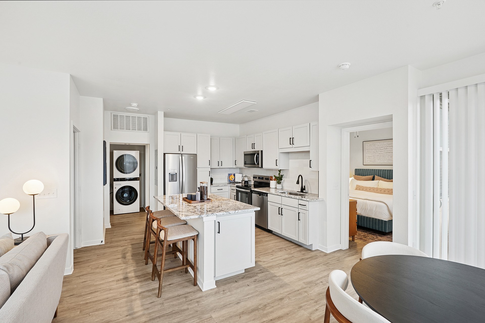 A modern kitchen with white cabinets and a wooden table.