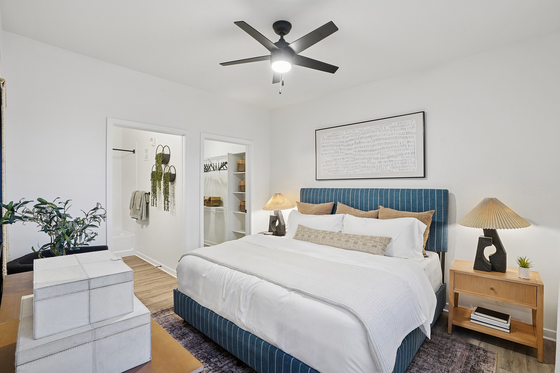 A bedroom with a large bed and a ceiling fan.