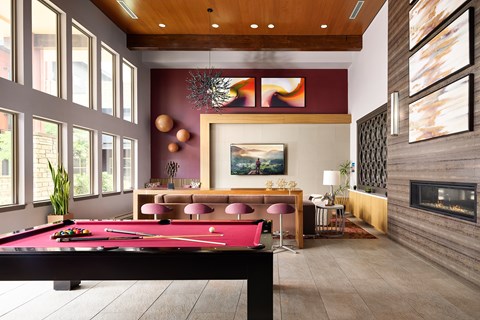 a red pool table in a living room with a fireplace