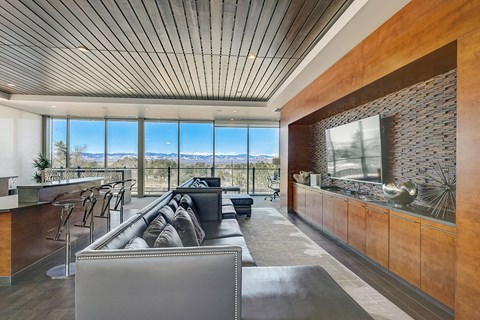 a living room with a couch and a bar and a view of the mountains