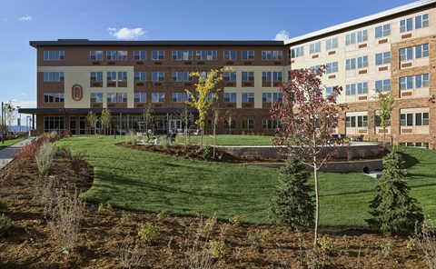 The exterior building with a front grass area at The Audrey Apartments in Highlands Ranch.