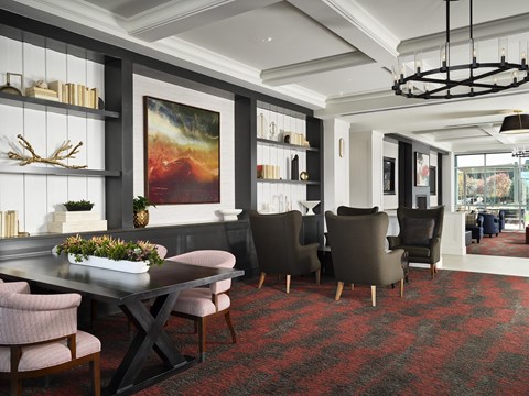 A modern dining room with a large painting on the wall and a table set for six.