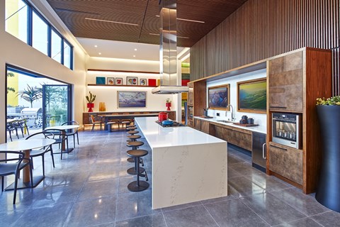 Kitchen with TVs and bar style seating at Symmetry apartments in Northridge.