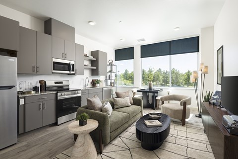 Modern kitchen with gray cabinets and a beautiful view out the window at Lofts on Monaco apartments in Denver.