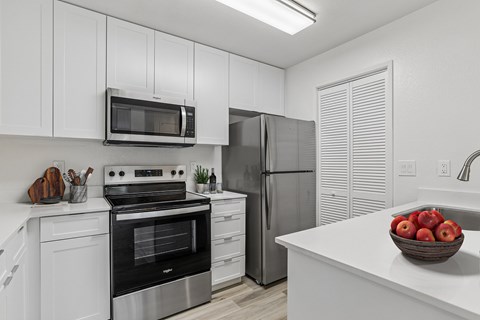Remodeled kitchen with quartz countertop and white shaker cabinets at Creekside Apartments in Fremont.