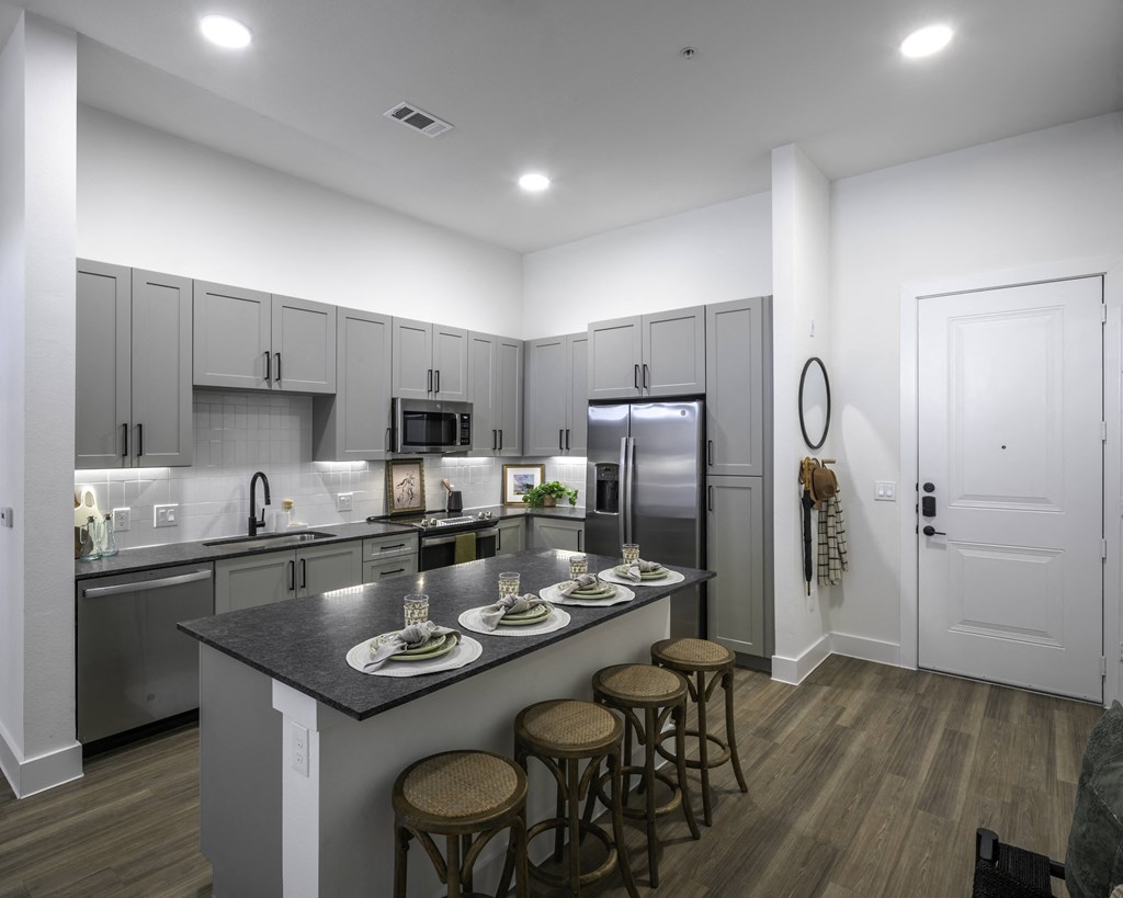 a kitchen with a large island with four stools