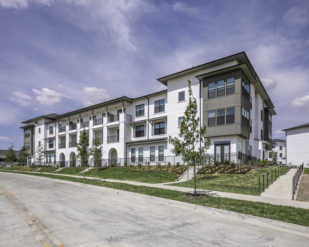exterior of apartment building with white exterior and gray roof
