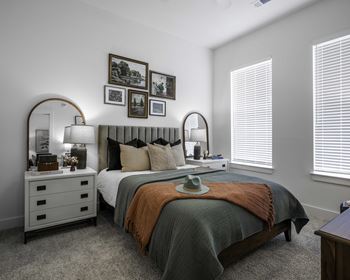 a bedroom with a bed and a dresser with a mirror on top of it