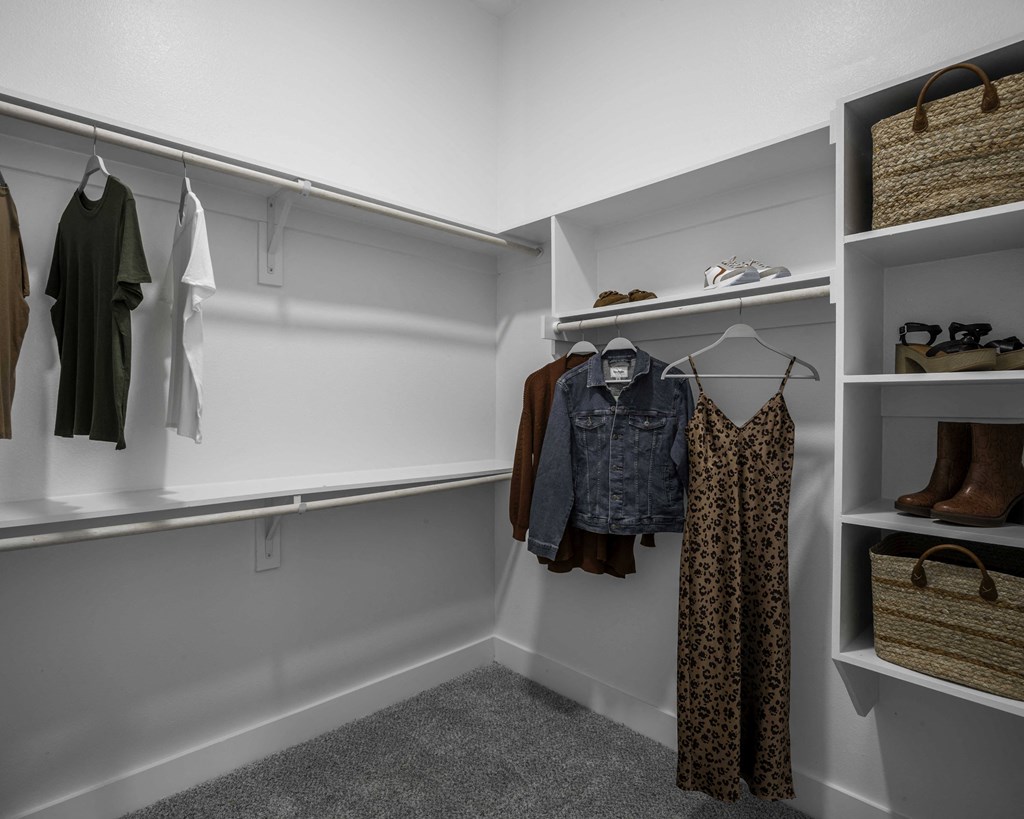 a walk in closet with white walls and built-in shelves