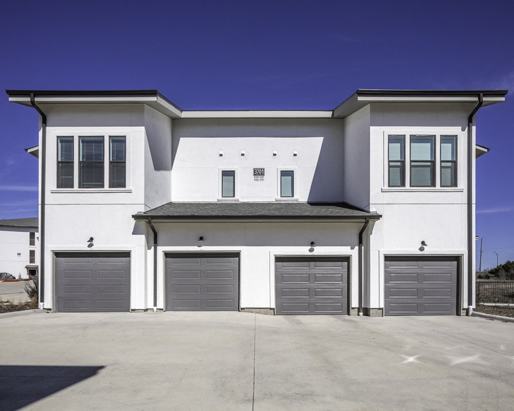 a white house with three garage doors