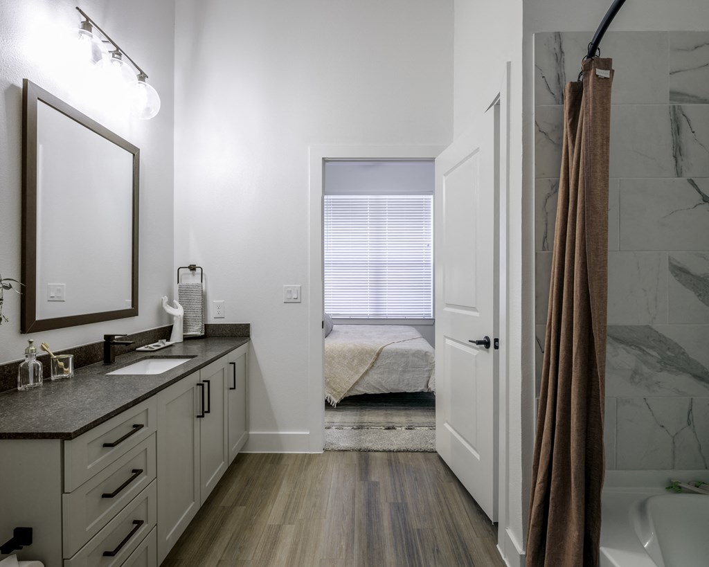 a bathroom with a shower and a sink and a mirror