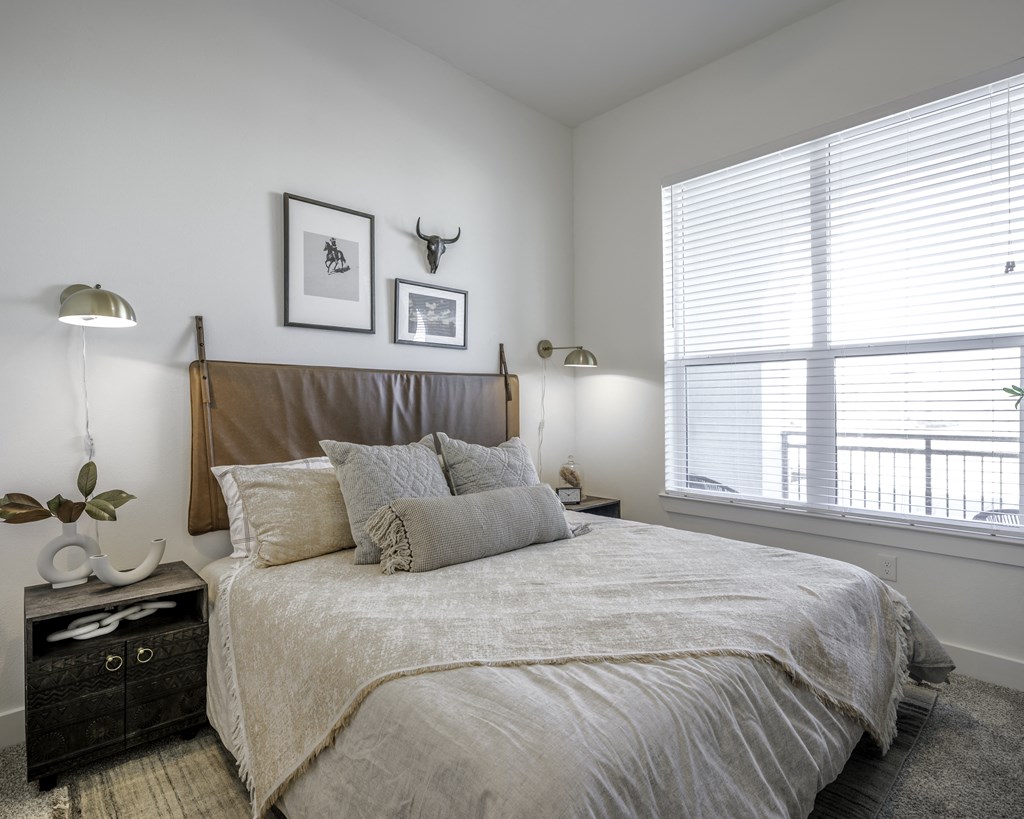 a bedroom with a large bed and two windows