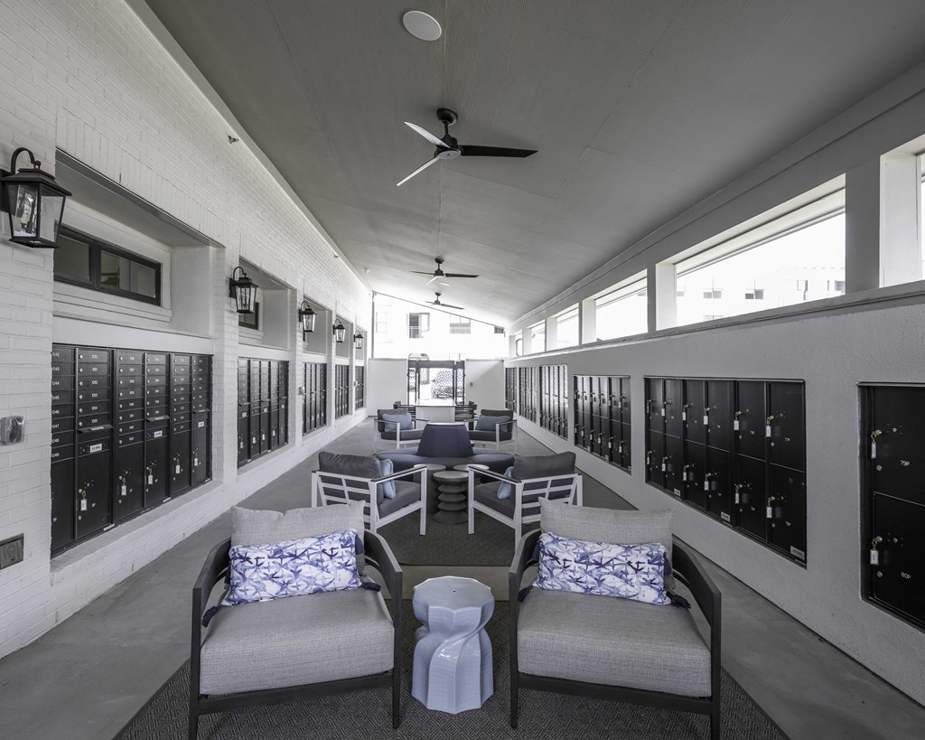 a lounge area with chairs and couches next to the mail lockers