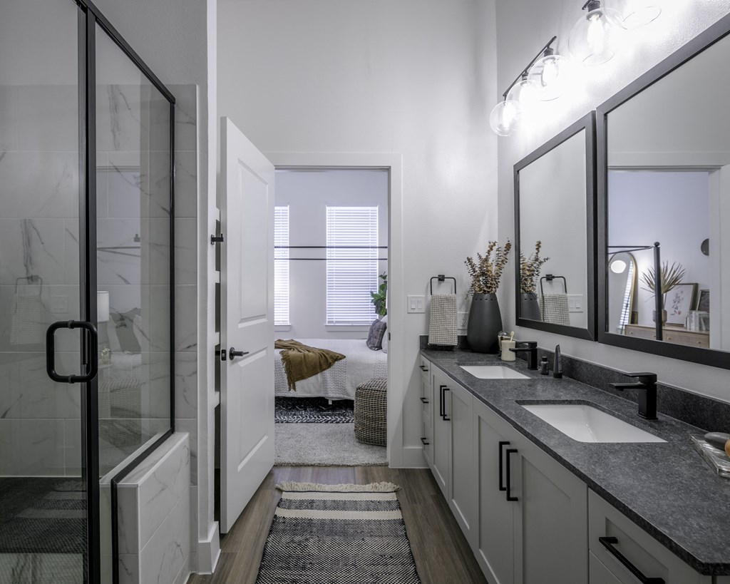 a bathroom with a sink and a shower and a mirror