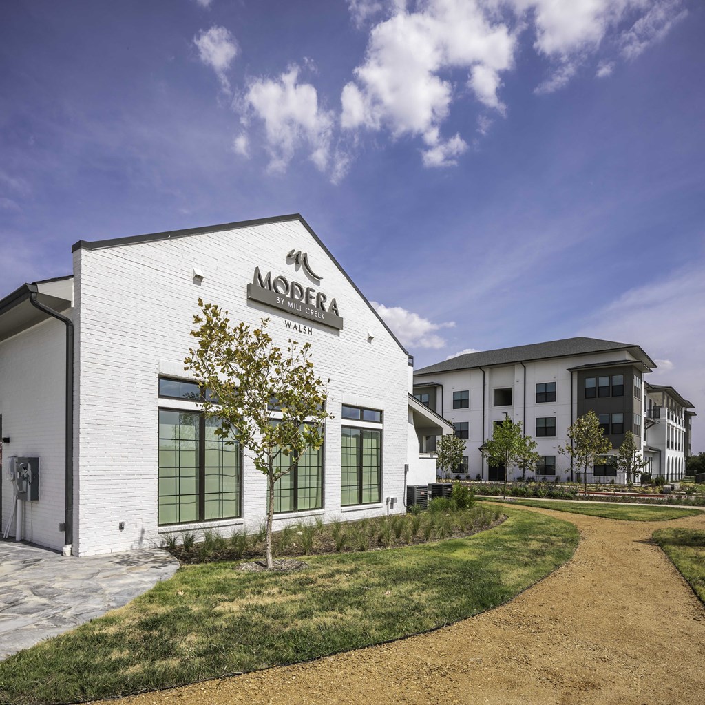 a white clubhouse building with a community signage
