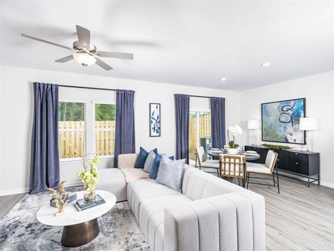 a living room with a white couch and a ceiling fan