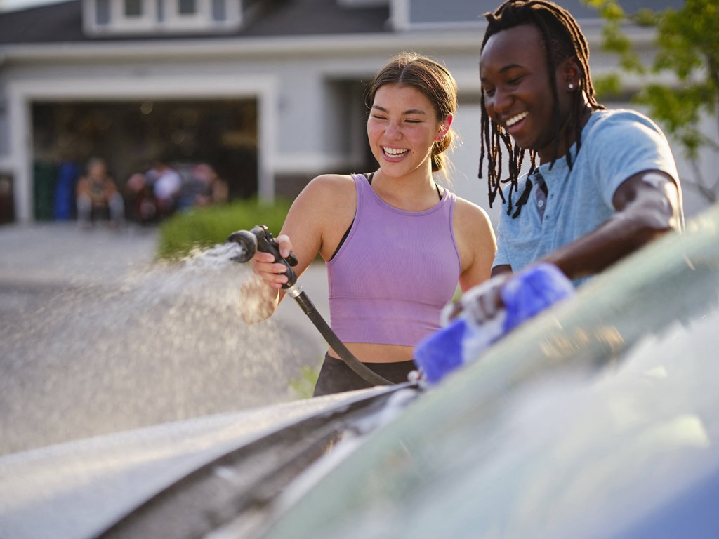 a man and a woman washing a car