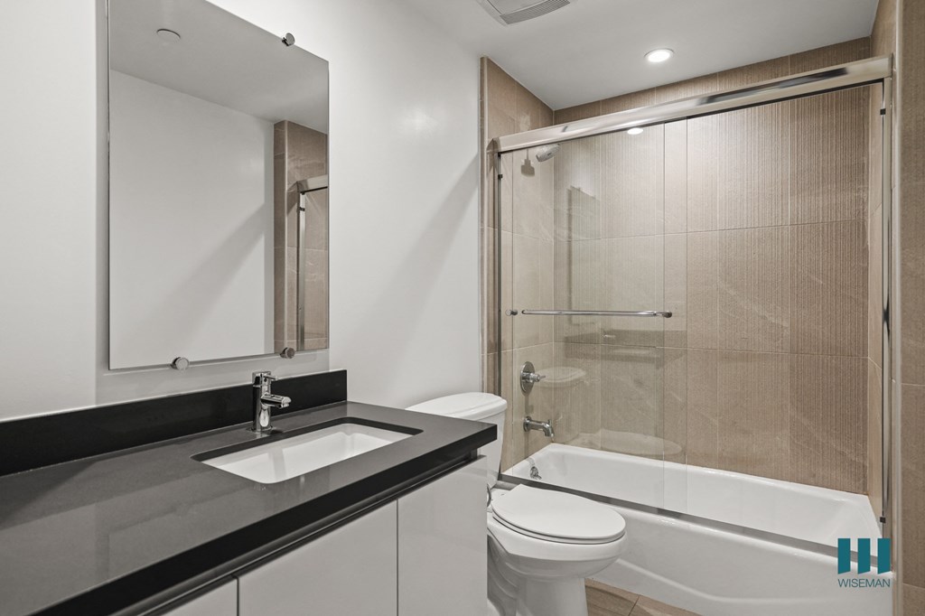 Bathroom with Bathtub with Glass Door and Vanity Cabinet Storage