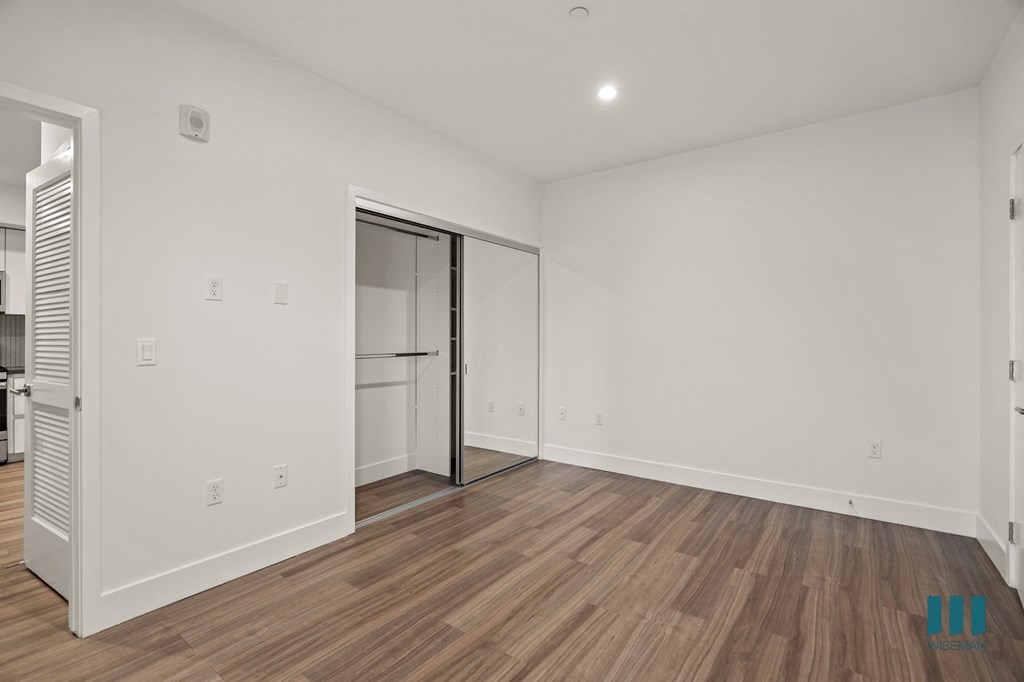 Bedroom with Mirrored Closet, Recessed Lighting, and Vinyl Flooring