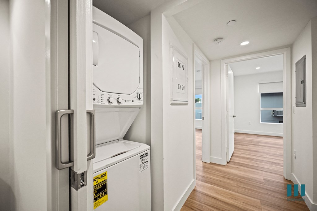 A white fridge with a yellow sticker on it.