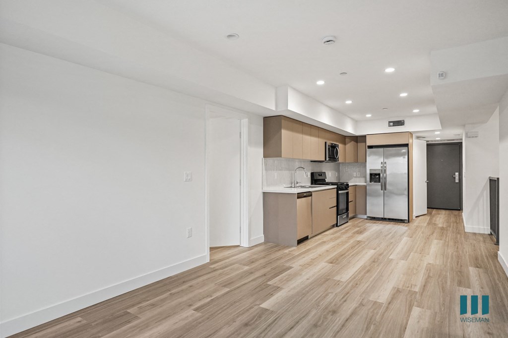 A kitchen with wooden floors and white walls.