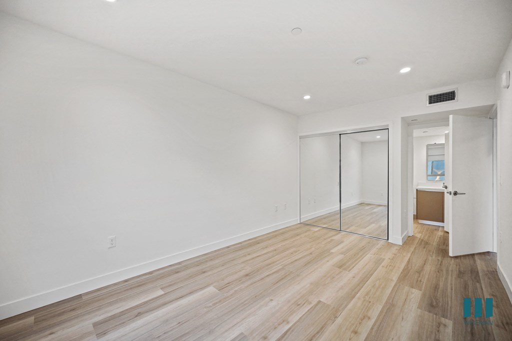 A room with wooden flooring and white walls.