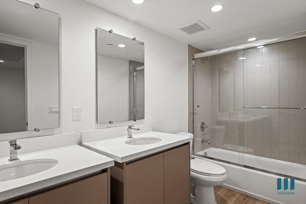 A bathroom with a white sink and brown cabinetry.