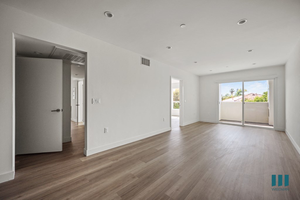 an empty living room with white walls and wooden floors