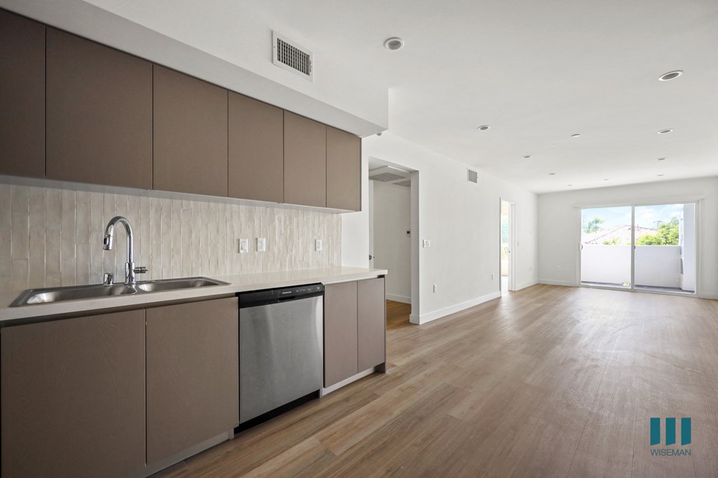 an empty kitchen with a sink and a dishwasher