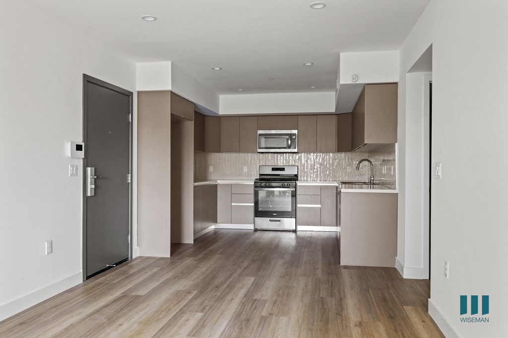 a view of a hallway with white walls and wood floors