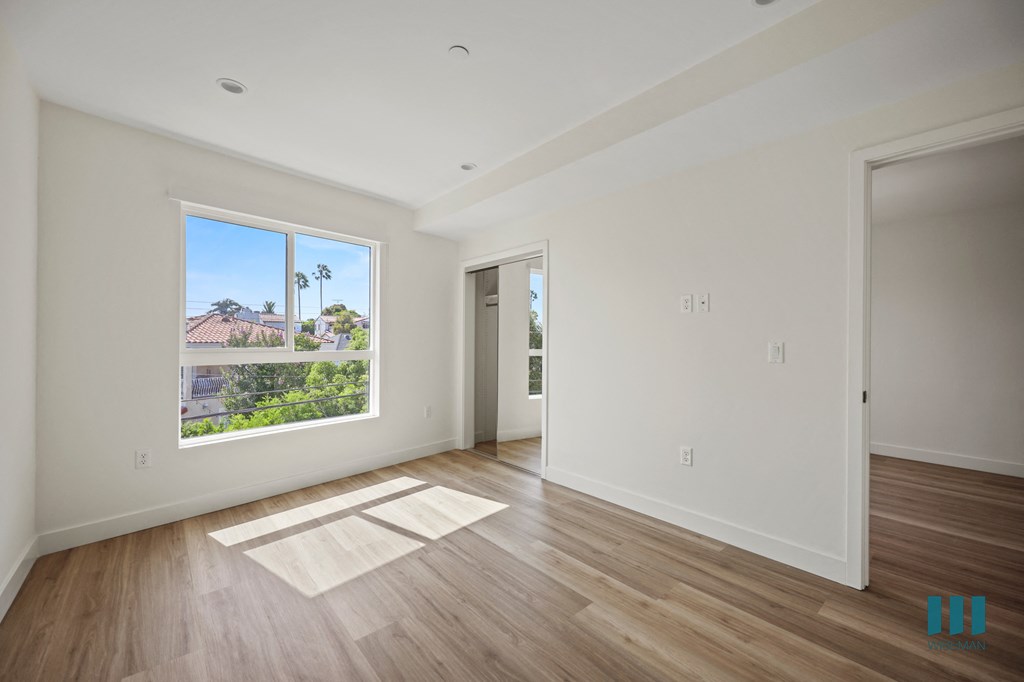 a view of a room with white walls and wood floors