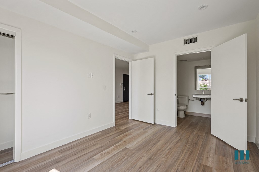 an empty living room with white walls and wood floors