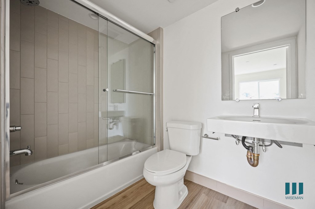 a bathroom with a toilet and a shower and a sink