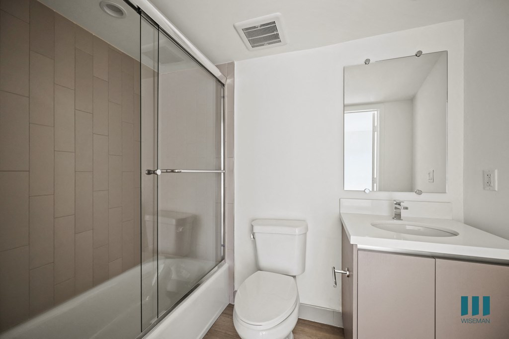 a white bathroom with a shower toilet and sink