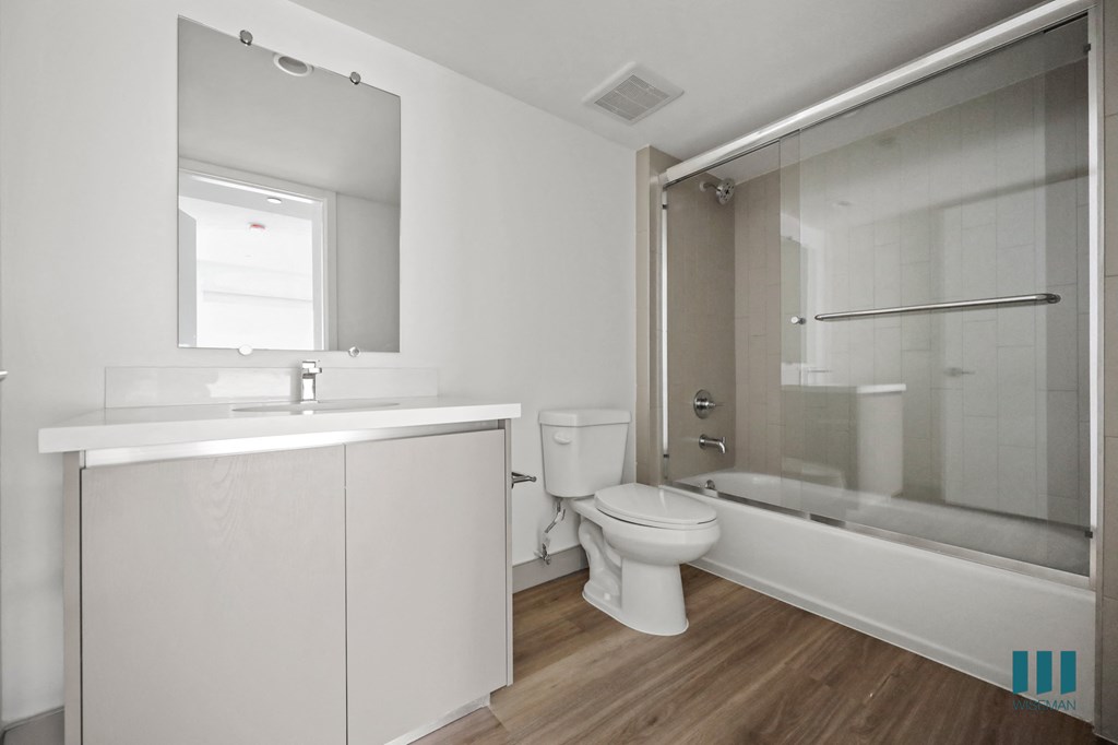 a bathroom with a shower toilet and sink and a mirror