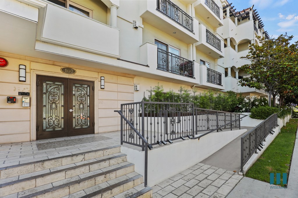 an apartment building with stairs and a brown and white door