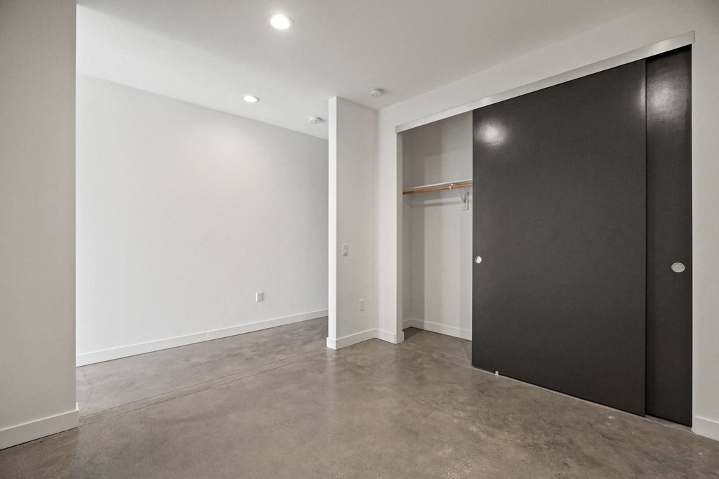 Bedroom with Large Closet and Concrete Flooring