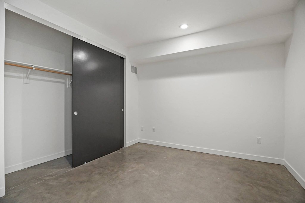 Bedroom with Recessed Lighting, Closet, and Concrete Flooring
