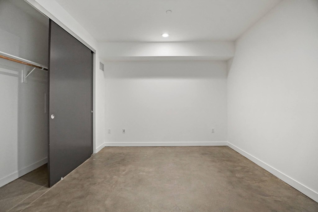 Large-Size Bedroom with Closet, Recessed Lighting, and Concrete Flooring