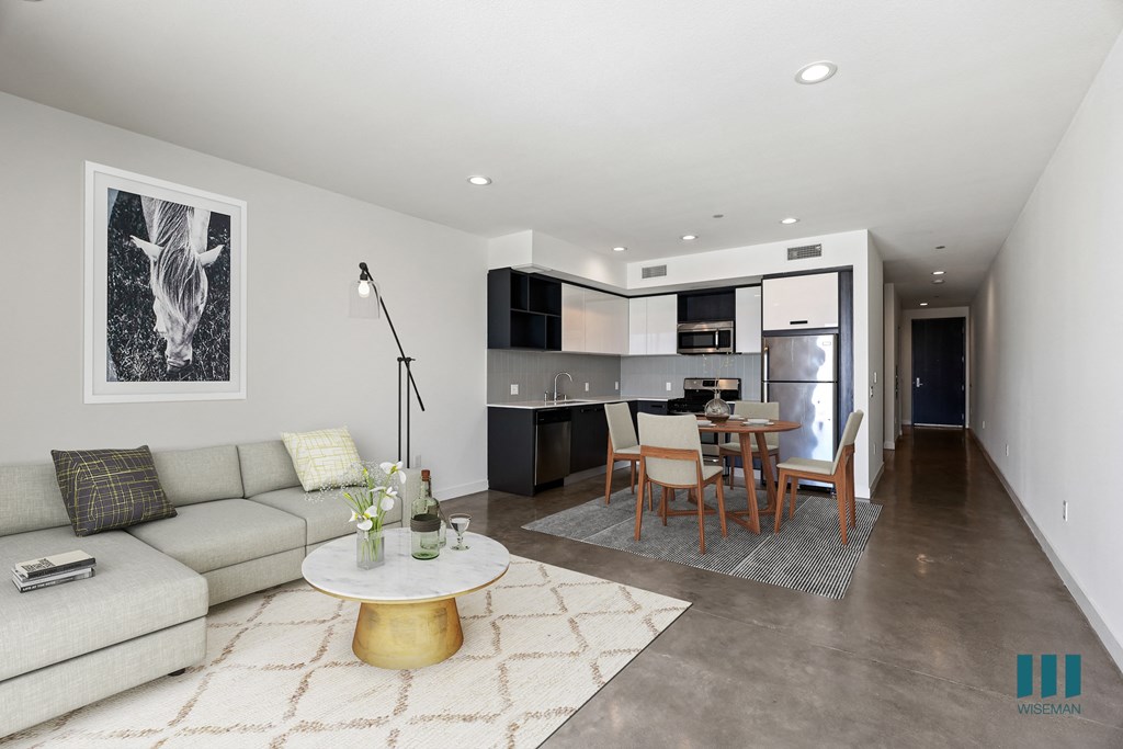 Open-Concept Kitchen, Dining, and Living Room Space with Concrete Flooring