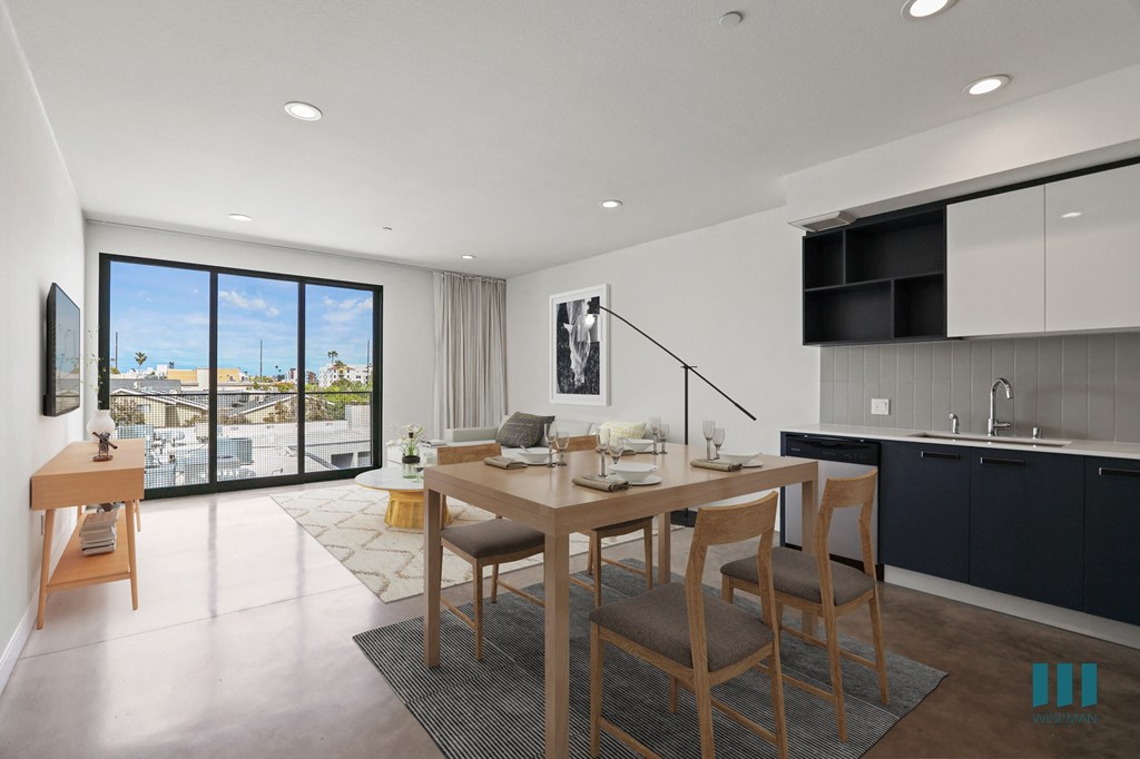 Open-Concept Kitchen, Dining, and Living Room Space with Concrete Flooring and Patio